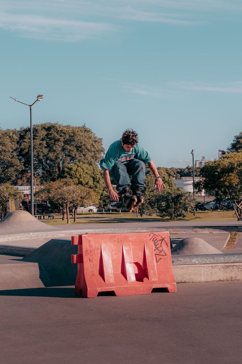 Free A skateboarder mid-air performing an impressive trick at an urban skatepark during the day. Stock Photo