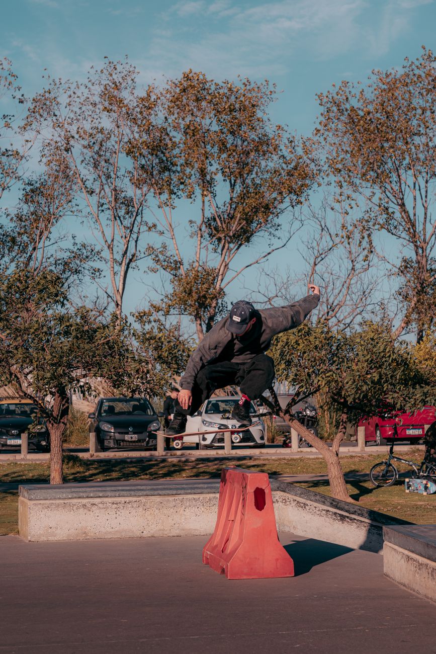 Dynamic capture of a skateboarder mid-air trick in an outdoor park setting.. dynamic, capture, skateboarder