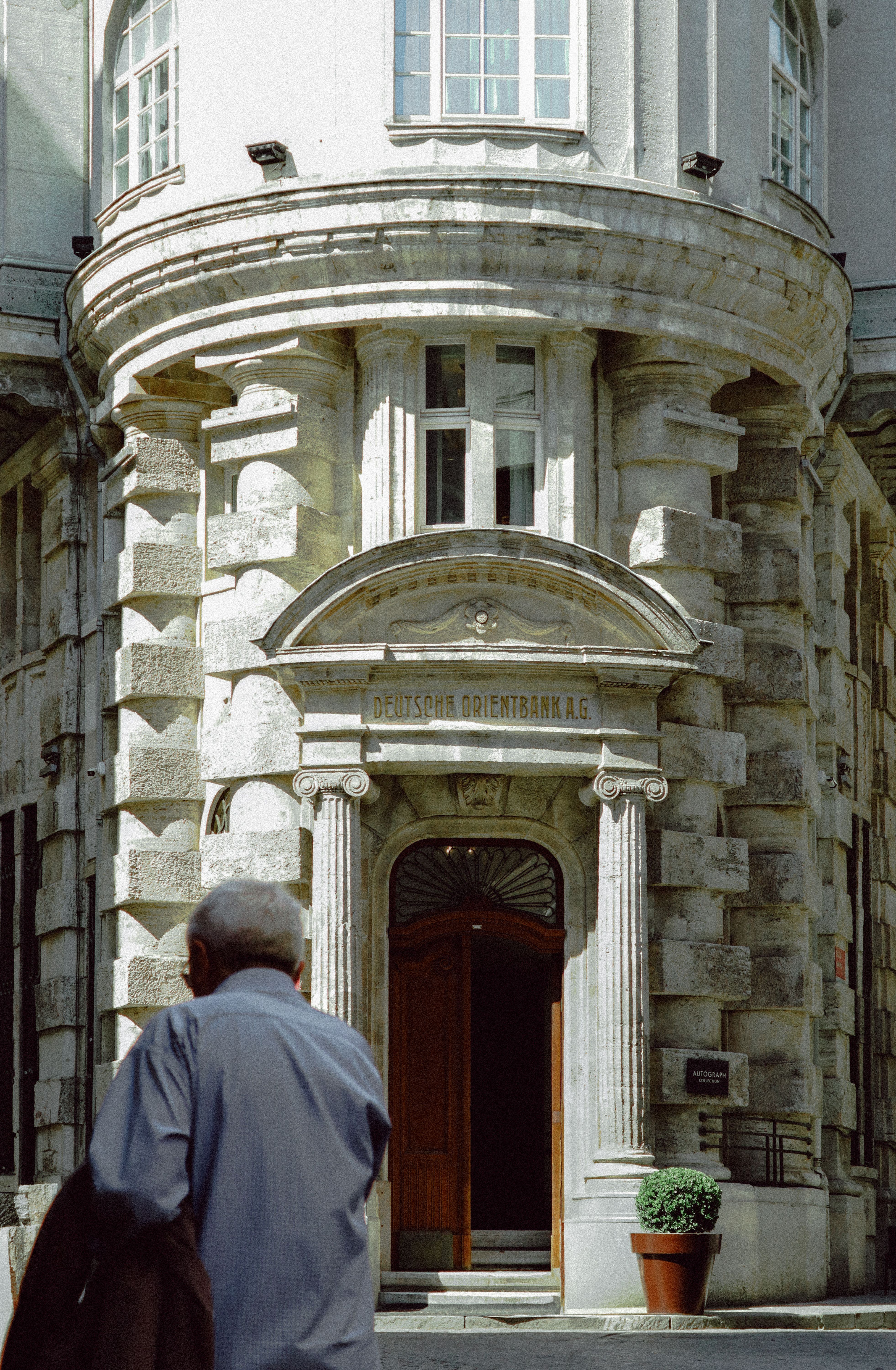 Historic Stone Building Entrance with Person Passing · Free Stock Photo