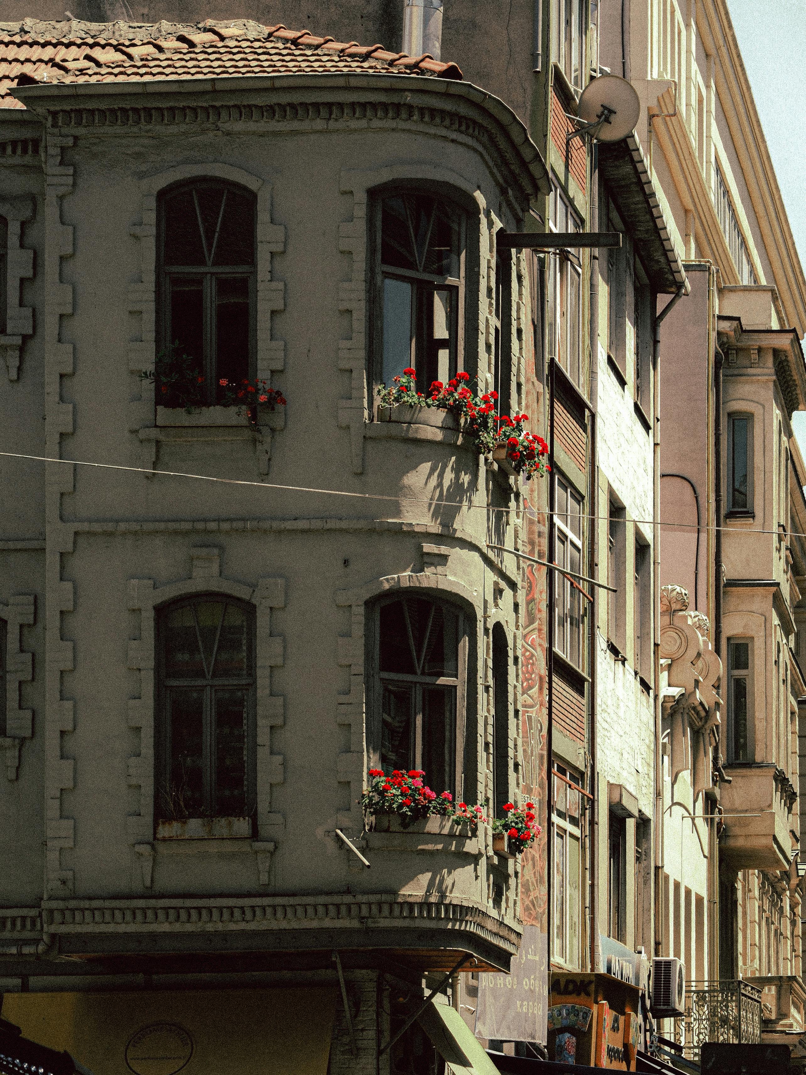 Charming vintage building facade in Europe with flowered balconies on a sunny day.