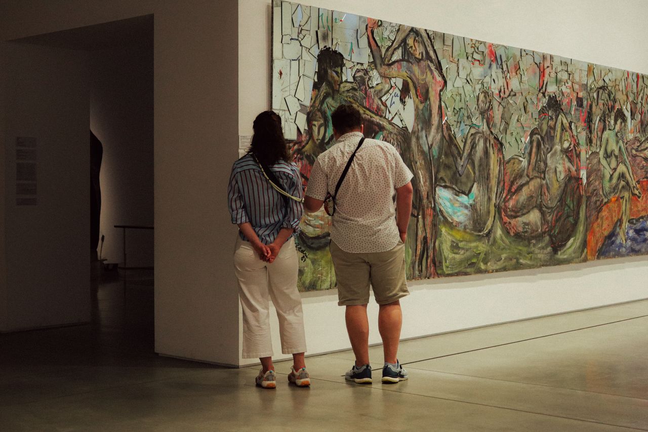 Two people in a gallery looking at a painting from different angles, representing two different "views."