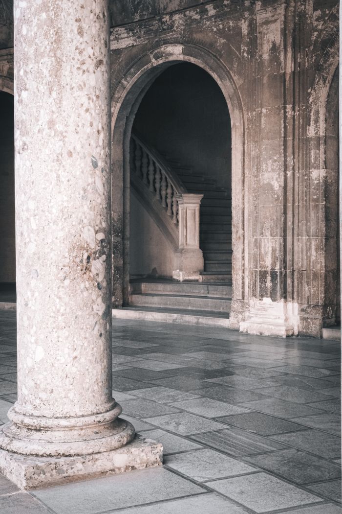 Weathered corridor with arched openings and a stone stair, by Nur Yilmaz on Pexels