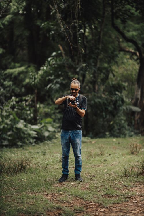 Free A photographer in a serene forest captures the beauty of nature. Stock Photo