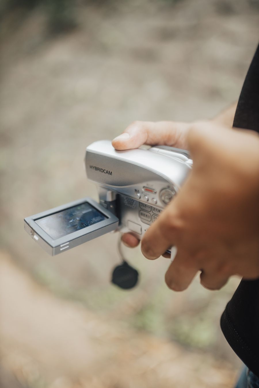 Hands holding a camcorder with its flip-out screen open