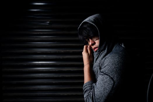 Mysterious portrait of a man in a hoodie, blending into shadows.