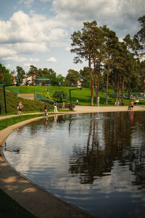 Free Peaceful park in Irpin, Kyiv Oblast, Ukraine, with people and a reflective pond. Stock Photo
