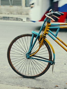 Close-up of a colorful vintage bicycle wheel on an urban street.