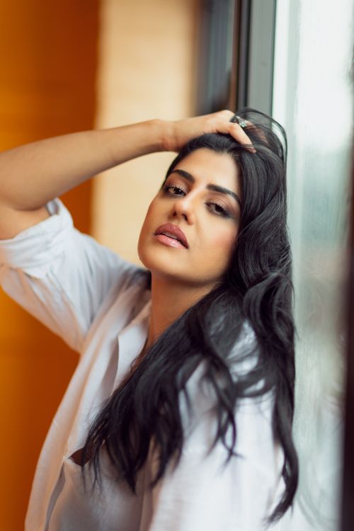 Free Stylish portrait of a woman in white shirt posing by a window. Stock Photo