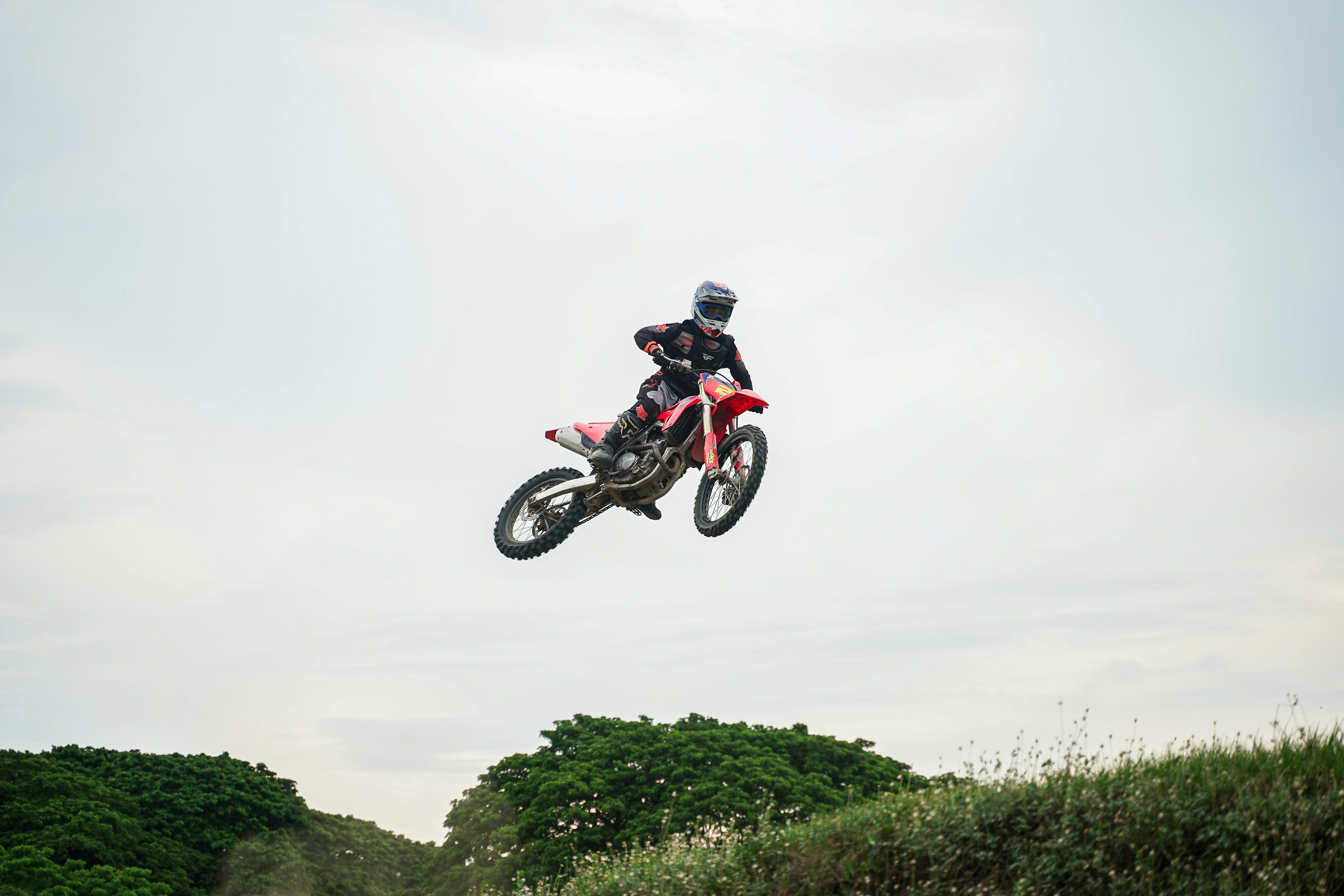 Thrilling motocross stunt with rider jumping high on a dirt bike in scenic Bulakan, Philippines.