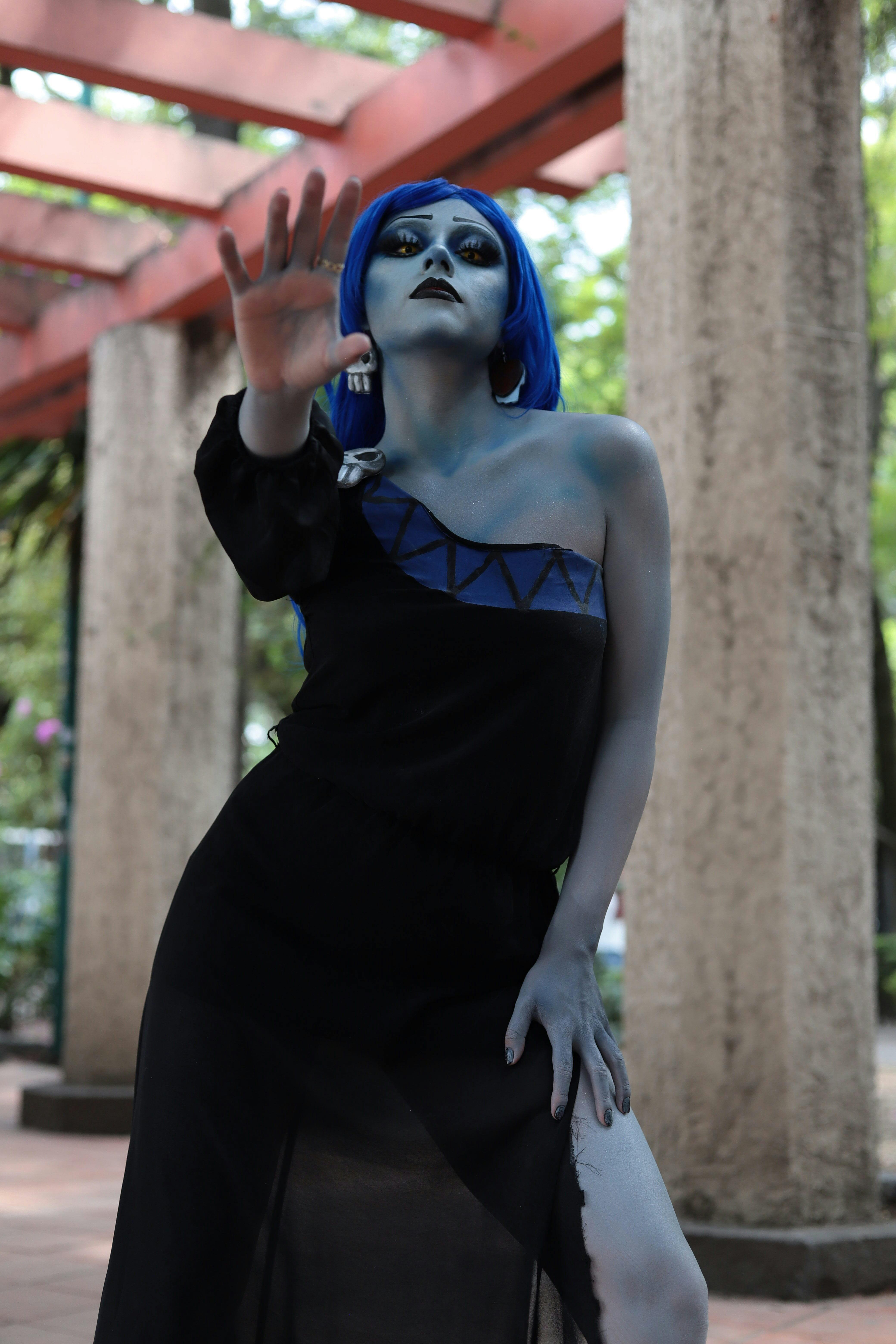 Ücretsiz Mavi makyaj ve kostümle dışarıda dramatik bir poz veren bir sanatçının çarpıcı portresi. Stok Fotoğraflar