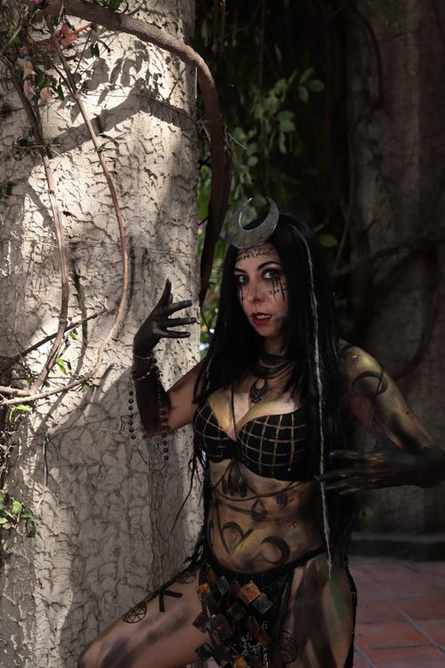 Free Mysterious woman in elaborate costume posing against an outdoor backdrop Stock Photo