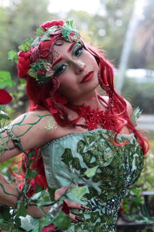 Free A captivating nature-inspired cosplay with vibrant red and green theme. Stock Photo