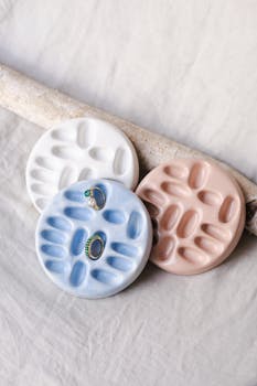 Artistic handmade ceramic jewelry holders in pastel colors with rings placed elegantly.