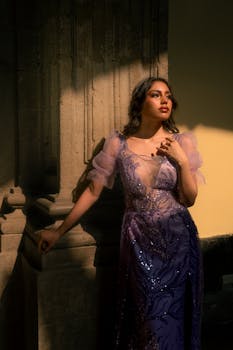 Stunning editorial photo of a woman in a luxurious purple gown, highlighted by dramatic lighting.