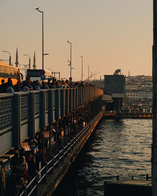 Free A vibrant scene capturing the bustling evening crowd on Galata Bridge, Istanbul, at sunset. Stock Photo