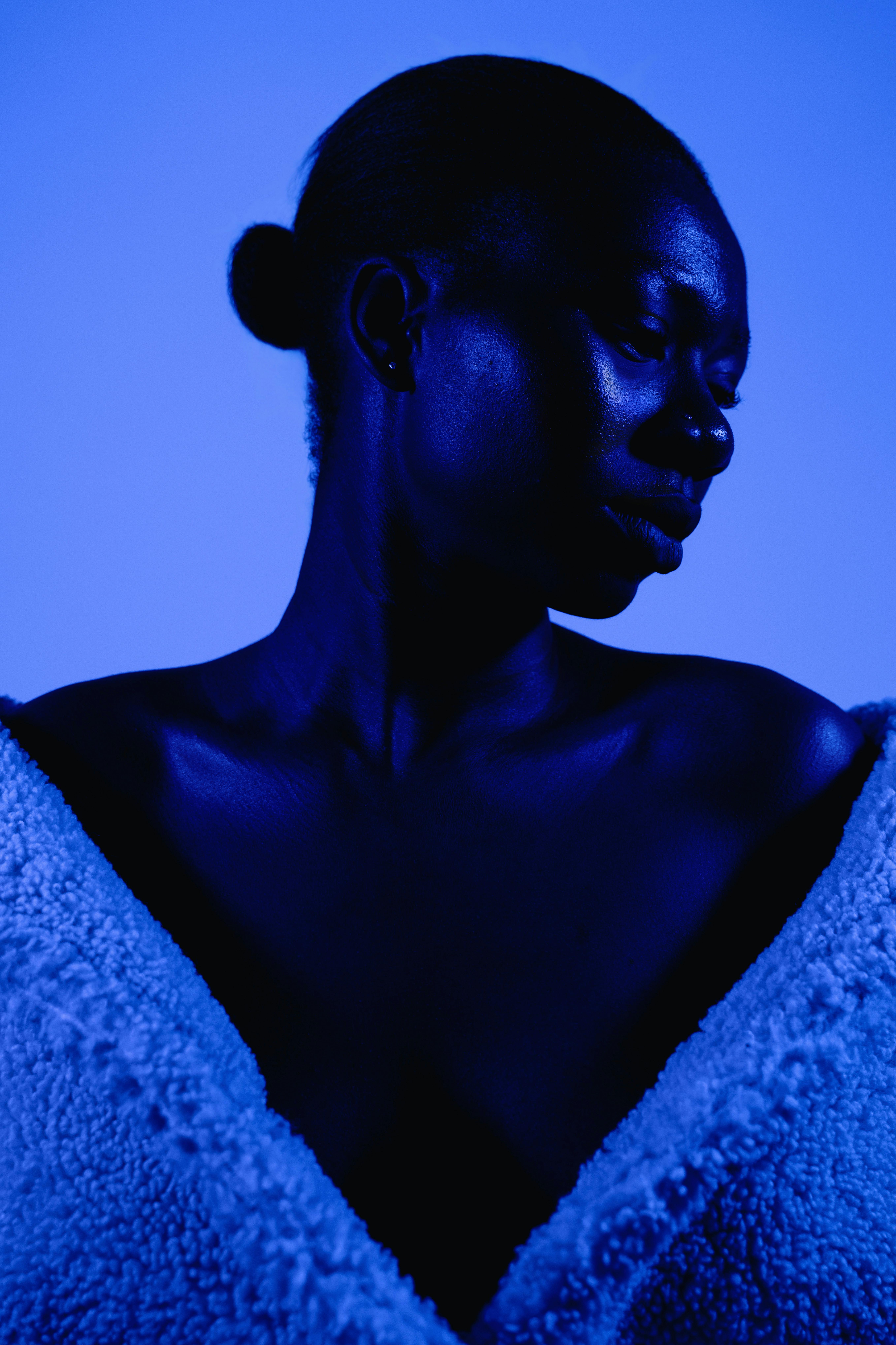 Striking portrait of a woman with blue lighting highlighting modern elegance.