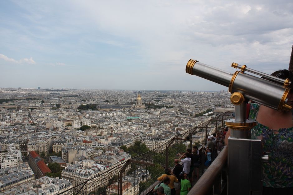 Panoramic view of Paris cityscape from the Eiffel Tower with a visible telescope.