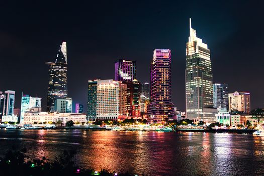 Stunning night view of Ho Chi Minh City's illuminated skyline reflecting on Saigon River.