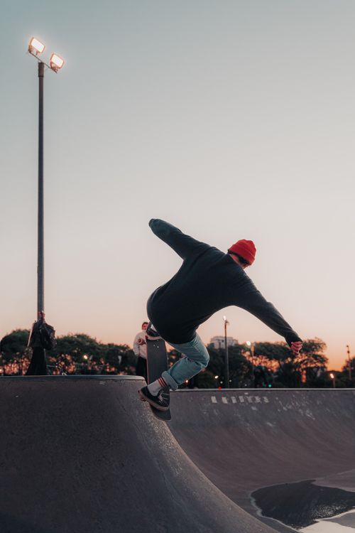 Free A skateboarder in action at a skatepark during sunset, showcasing urban skate culture. Stock Photo