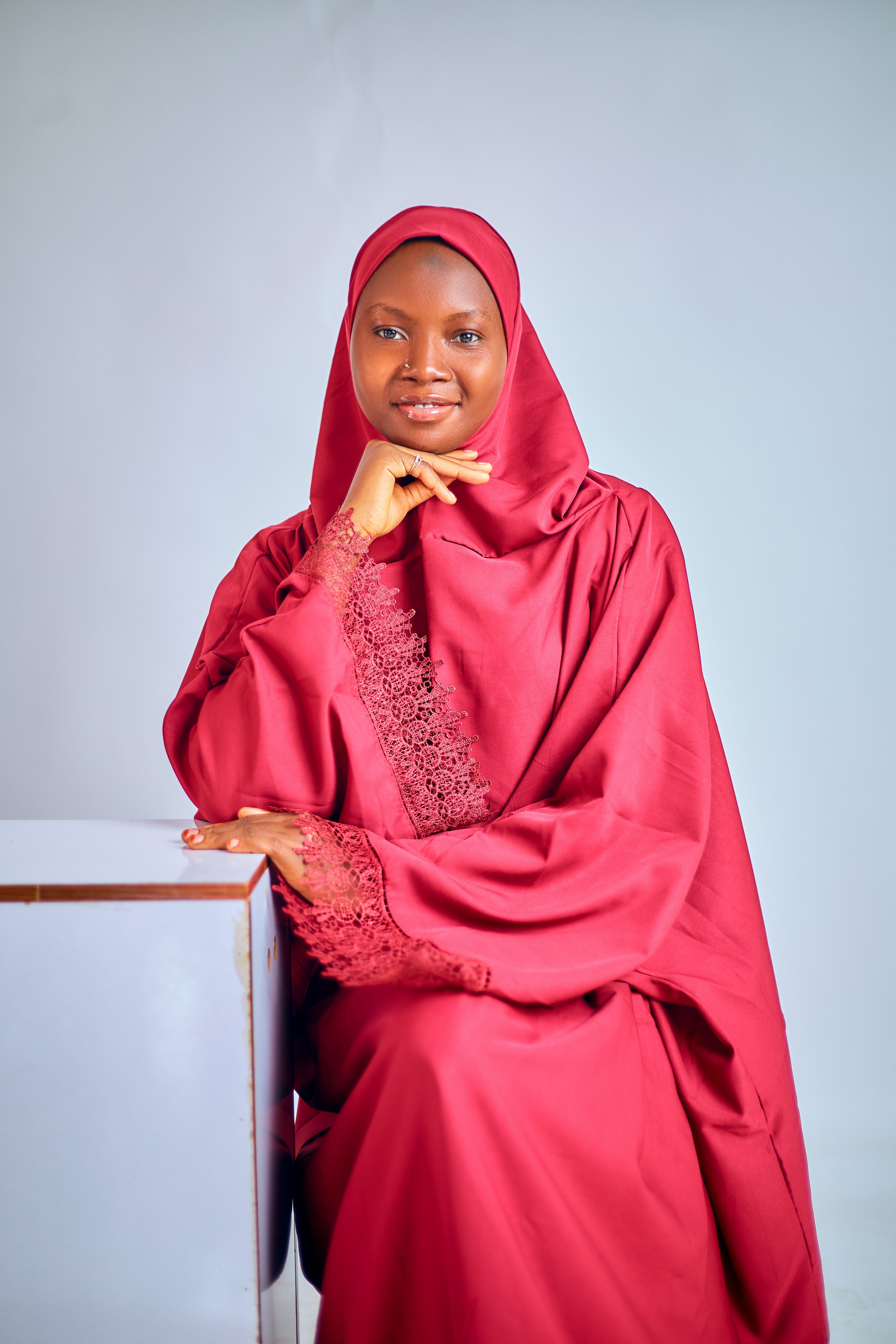 Sophisticated portrait of a woman in a maroon hijab, exuding grace and elegance.