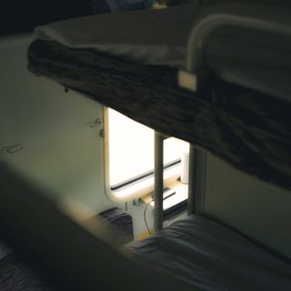 Sleep pod bunk with a reading light — photo by 天 明 on Pexels