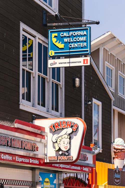 Free A vibrant street scene featuring the California Welcome Center and Trish's Mini Donuts sign in San Francisco. Stock Photo