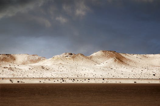 Captivating view of a desert landscape in Dakhla, with striking sand dunes under dark, moody skies.