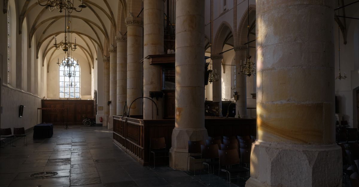 A quiet corner inside an ancient European cathedral with sunlight streaming through stained glass