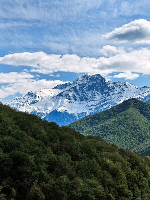 Free Stunning view of a snow-capped mountain with lush green forest in Syunik, Armenia. Perfect for nature lovers. Stock Photo