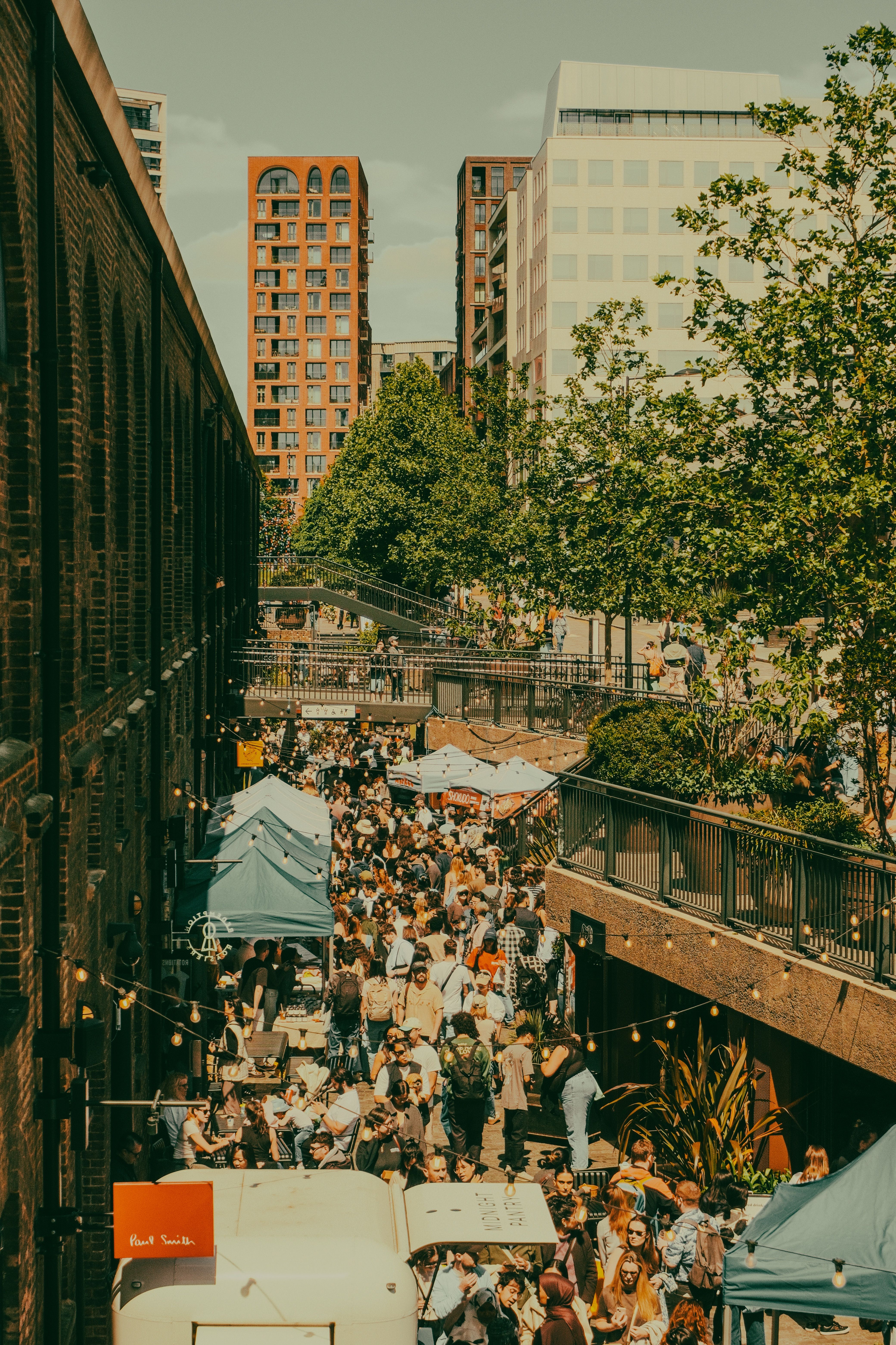 Independent food stalls lining the railway arches at Maltby Street Market in Bermondsey, London on a weekend