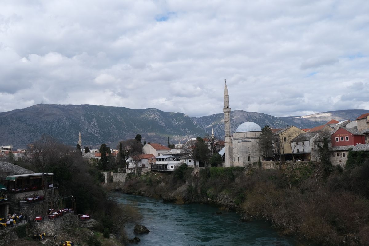 Mostar văzut de sus, cu râul Neretva, un minaret și munții din spatele orașului