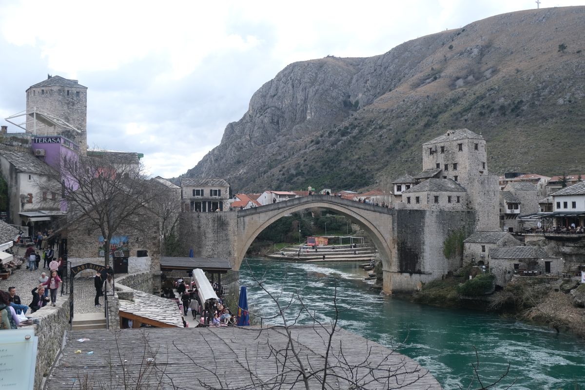 Stari Most bridge spanning the Neretva River in Mostar with mountains behind
