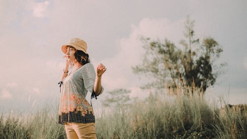 Fotografi Fokus Selektif Wanita Berdiri Yang Mengenakan Topi Coklat