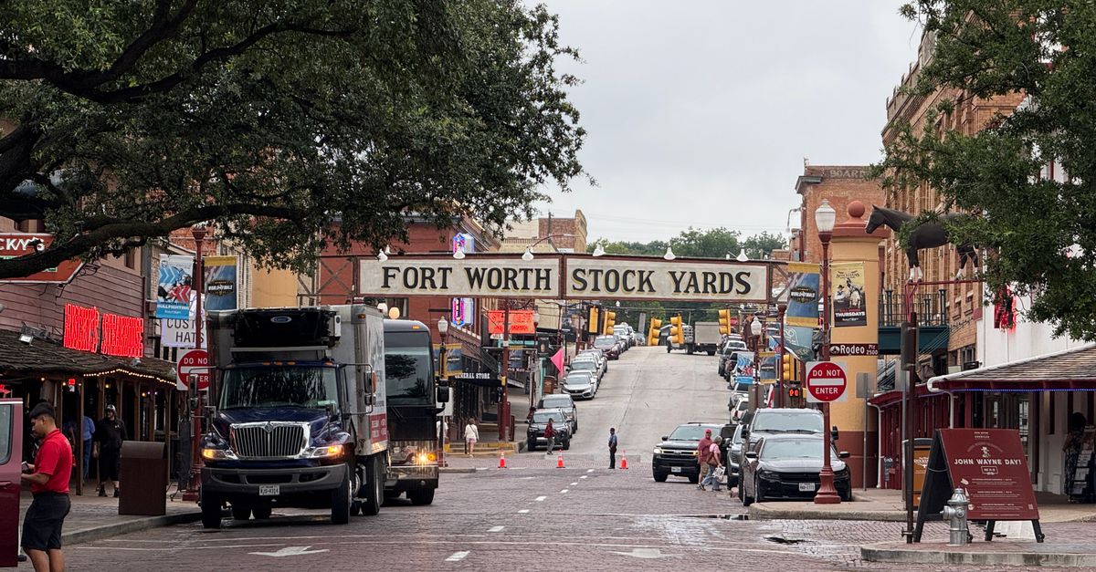 View of the historic Fort Worth Stockyards with bustling street and classic architecture in Texas.