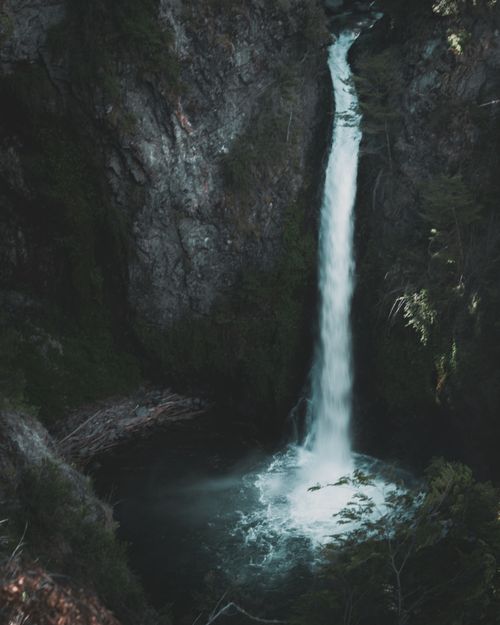 Free A stunning waterfall cascading in Vila La Angostura's lush greenery, Argentina. Stock Photo