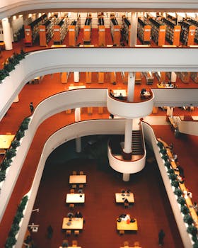 A stunning view of the architectural interior of Toronto Central Library featuring spiral stairs and study areas.