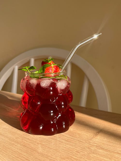 Free Stylish glass with a refreshing hibiscus and peppermint drink, garnished with strawberries. Stock Photo