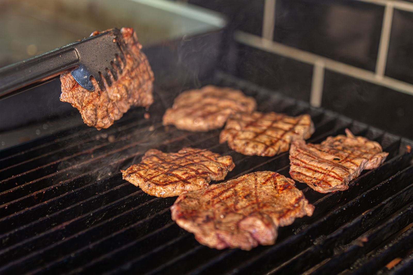 Juicy steaks sizzling on a hot grill with deep sear marks
