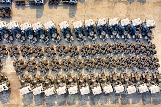 Aerial shot of multiple trucks parked in rows, highlighting transportation logistics.