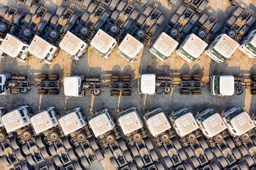 Aerial view of numerous trucks parked neatly in rows in a Jakarta depot, showcasing transportation logistics.