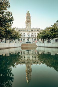 A stunning reflection of Porto City Hall with symmetrical water reflections captured in daylight.