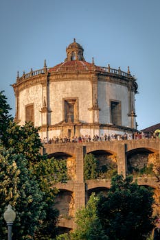 Capture of Serra do Pilar Monastery in Porto during a sunny day with vibrant greenery in the foreground.