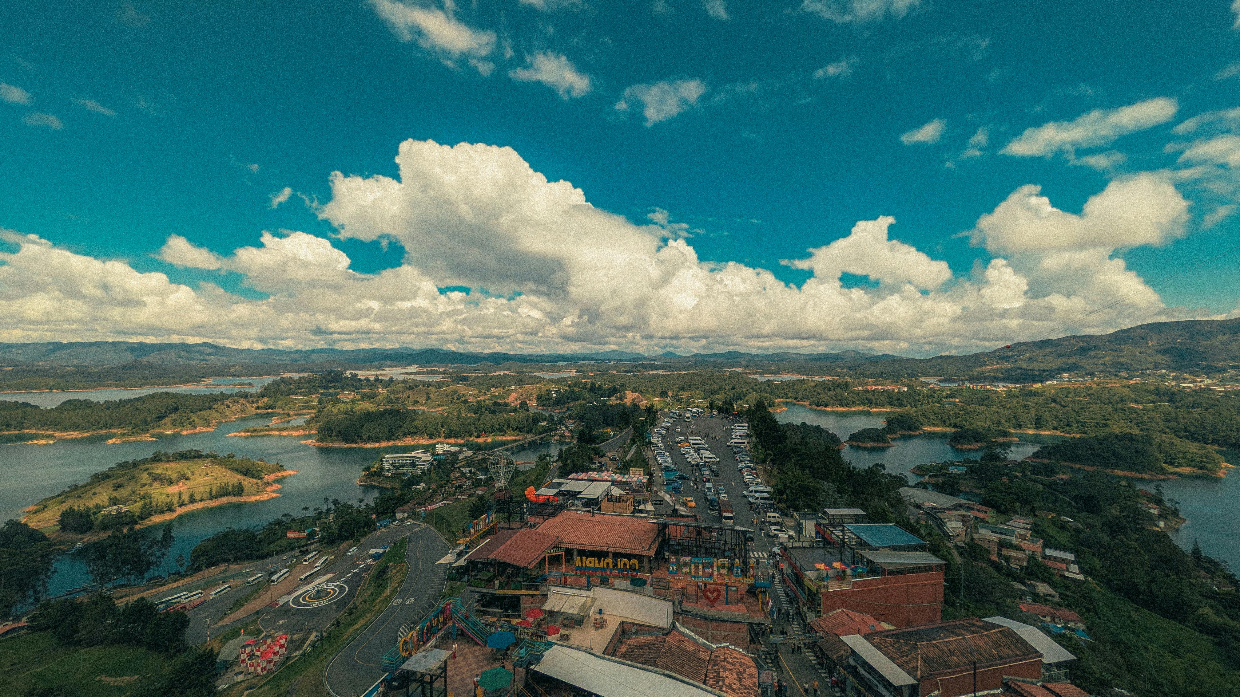 Beautiful aerial view of Guatapé, Antioquia, highlighting the lakes and mountains under a vibrant sky.