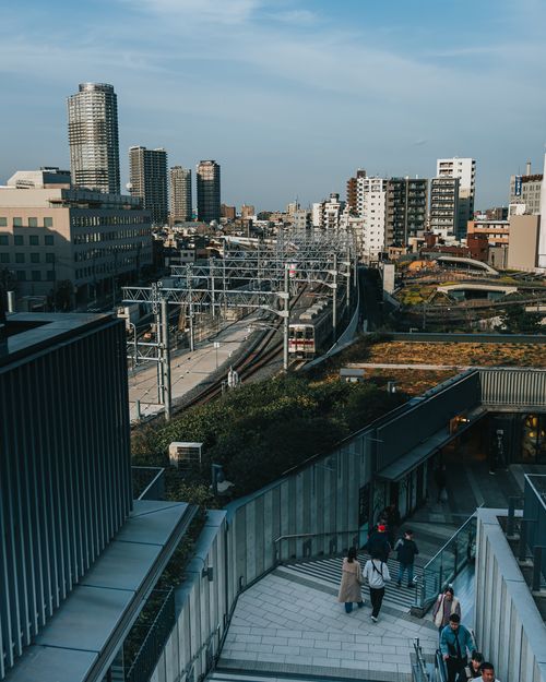 Free A vibrant cityscape featuring railway tracks and high-rise buildings under a clear sky. Stock Photo