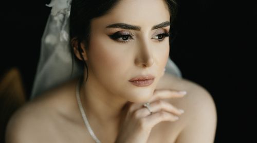 Free Close-up portrait of a thoughtful bride with elegant makeup and a white veil. Stock Photo