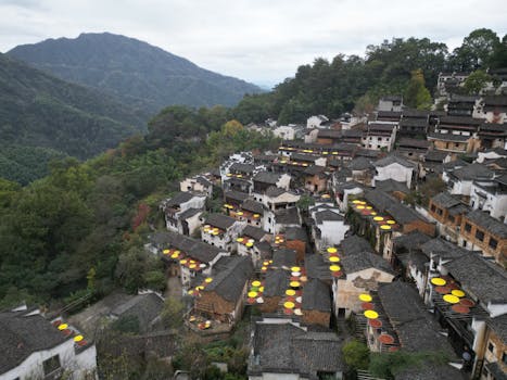 Aerial view of Hongcun village showcasing traditional Chinese architecture and corn drying on rooftops.