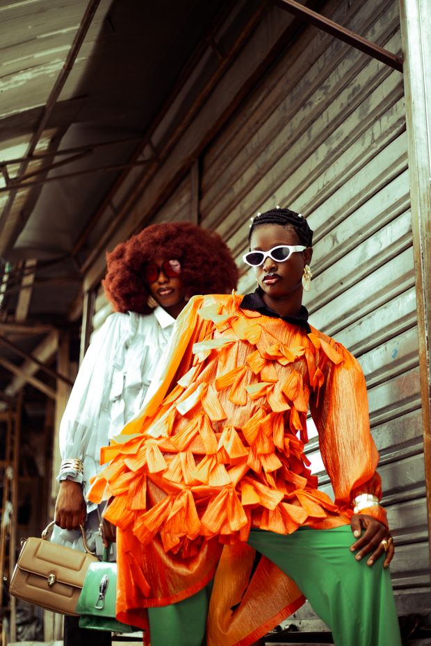 Two people in bold layered outfits on a covered street, photo by Adefemi Adedoyin on Pexels