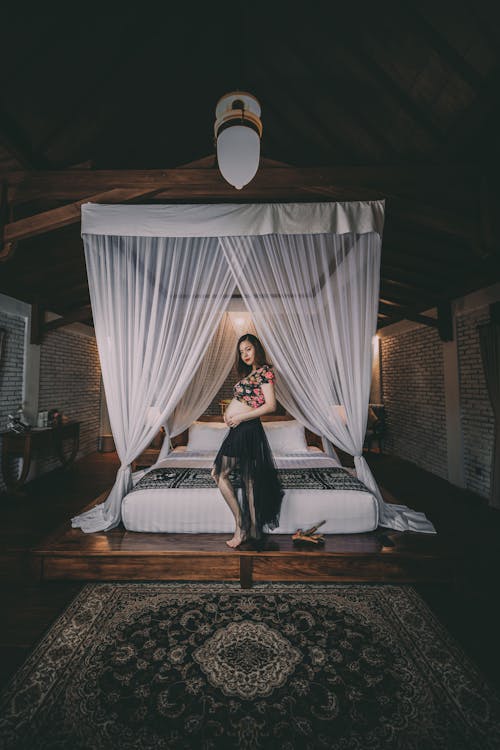 бесплатная Фотография беременной женщины возле кровати Стоковое фото