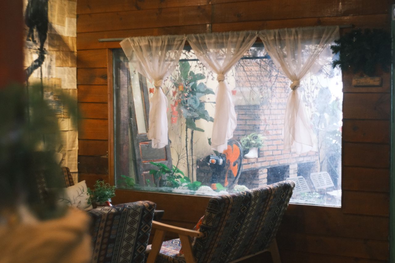 warm rustic indoor space with chairs and a window overlooking a garden