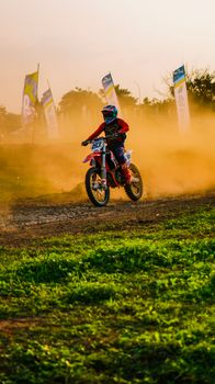 A vibrant motocross action shot during dusk in Jakarta, showcasing skilled off-road biking maneuvers.